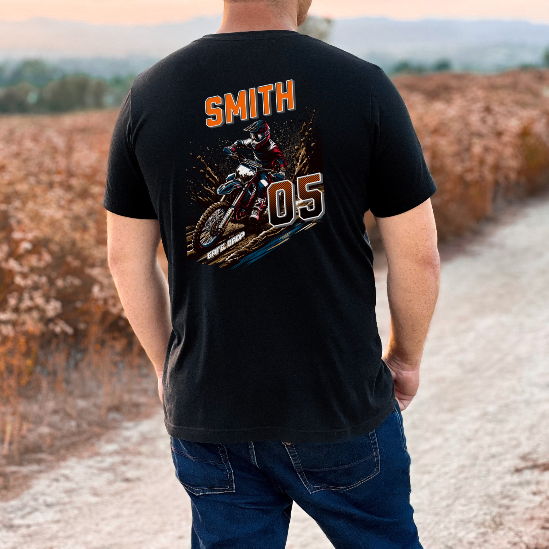Person wearing a black t-shirt with a graphic design and text, standing outdoors.