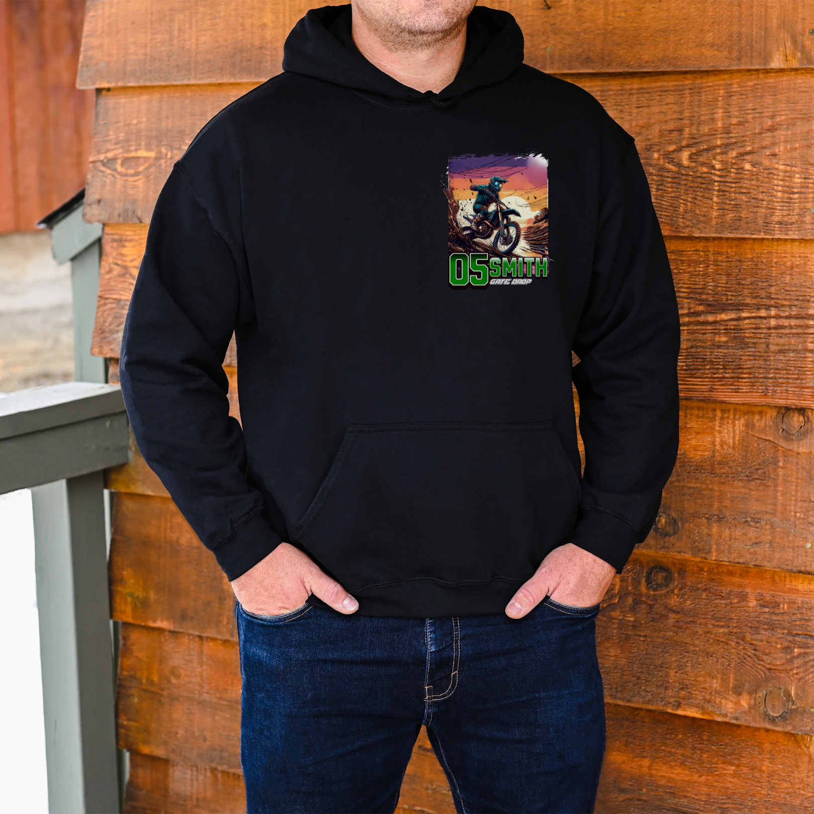 Person wearing a black hoodie with a graphic design on a wooden background