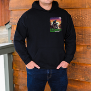 Person wearing a black hoodie with a graphic design on a wooden background