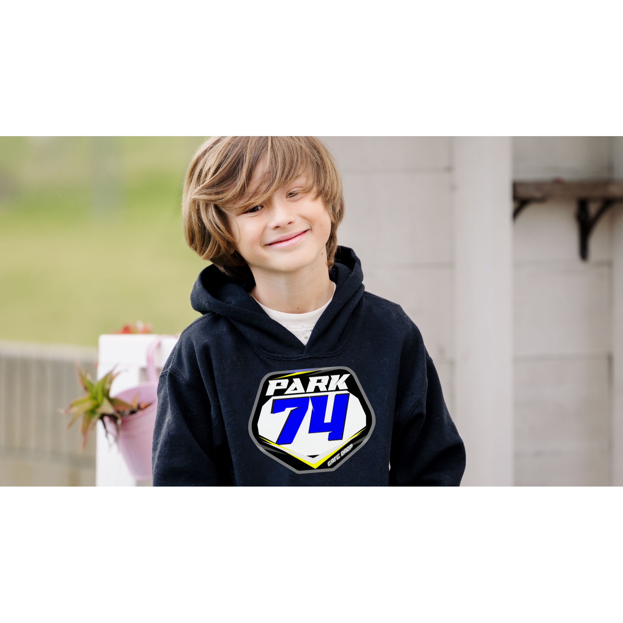 A youth wearing a black hoodie with a front pouch pocket, featuring a custom plate design with his name and number and a graphic element in a lighter color on the chest area.